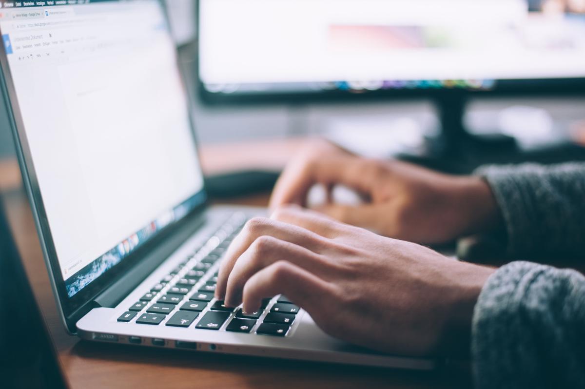 An image of a person using a virtual assistant on a laptop.